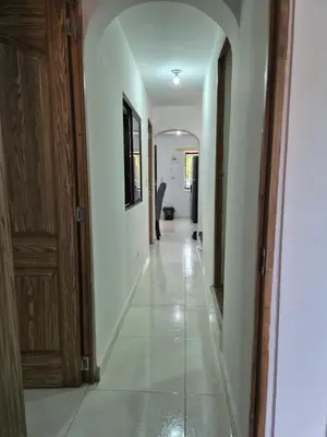 a hallway with white walls and a white tile floor at ECXEPCIONAL y ELEGANTE APARTAMENTO in Medellín