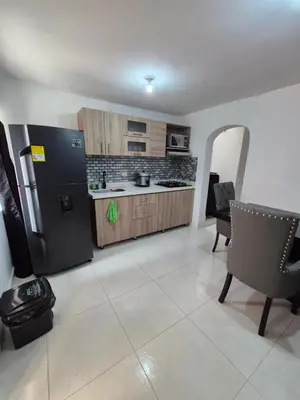 a kitchen with a refrigerator and a table and chairs at ECXEPCIONAL y ELEGANTE APARTAMENTO in Medellín