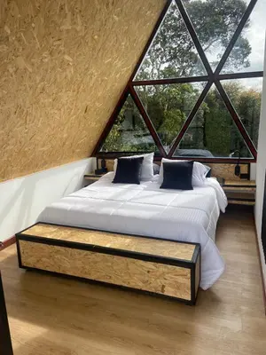 a large bed in a room with a large window at Pietrasanta Home in Rionegro