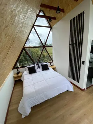 a bedroom with a large bed and a large window at Pietrasanta Home in Rionegro