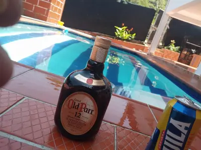 a bottle of wine sitting next to a swimming pool at Finca el encanto in San Carlos