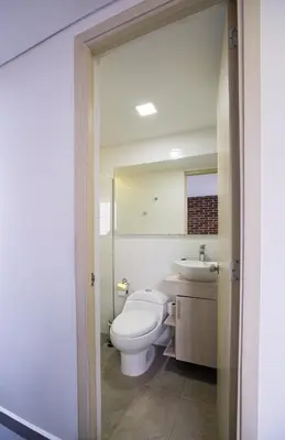 a bathroom with a toilet and a sink and a mirror at Beautiful apt in Poblado-Tesoro Near Provenza! in Medellín