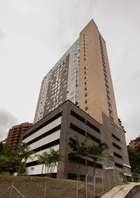 a tall building with palm trees in front of it at Beautiful apt in Poblado-Tesoro Near Provenza! in Medellín