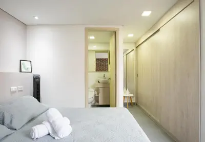 a bedroom with a white bed and a bathroom at Beautiful apt in Poblado-Tesoro Near Provenza! in Medellín