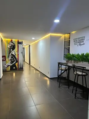 a hallway with a table and chairs in a building at Hotel LAX78 in Medellín