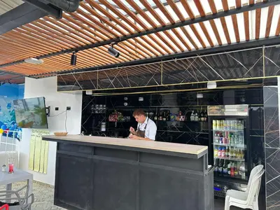 a man standing at a bar in a restaurant at Hotel LAX78 in Medellín
