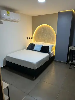 a bedroom with a large bed with a large headboard at Hotel LAX78 in Medellín
