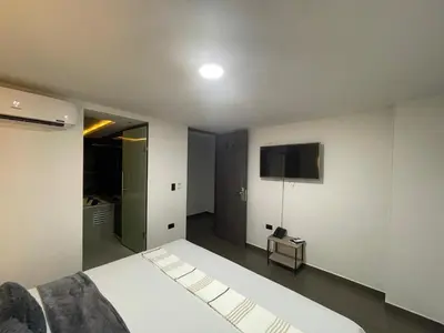 a bedroom with a bed and a tv on the wall at Hotel LAX78 in Medellín