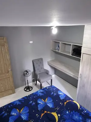 a bedroom with a bed and a chair and a desk at BONITO y ELEGANTE APARTAMENTO in Medellín