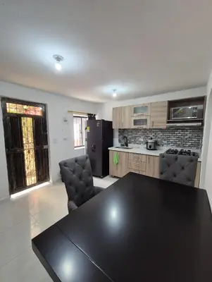 a kitchen with a black table and chairs in a room at BONITO y ELEGANTE APARTAMENTO in Medellín
