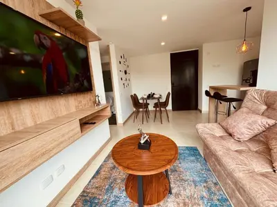 a living room with a couch and a table at Espectacular vista, apto de lujo, piscina, gym in Manizales