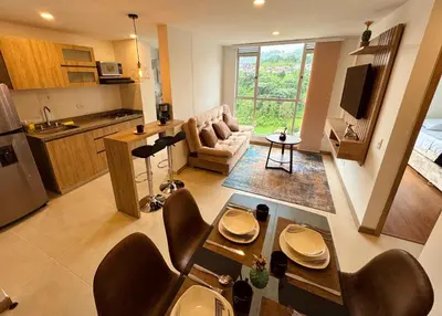a kitchen and living room with a table and chairs at Espectacular vista, apto de lujo, piscina, gym in Manizales