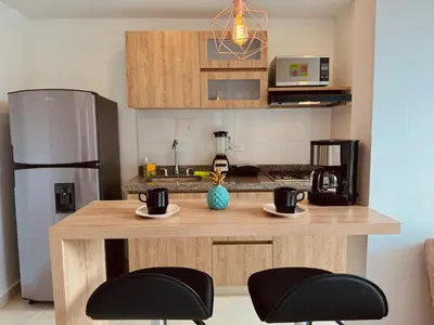 a kitchen with two mugs on a counter with a refrigerator at Espectacular vista, apto de lujo, piscina, gym in Manizales