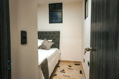 a bedroom with a bed with a black headboard at Apartamento Rosales in Medellín