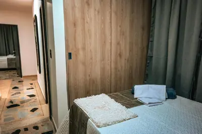 a bedroom with a bed and a wooden door at Apartamento Rosales in Medellín