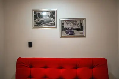 a red couch in a room with two pictures on the wall at Apartamento Rosales in Medellín