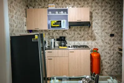 a small kitchen with a refrigerator and a microwave at Apartamento Rosales in Medellín