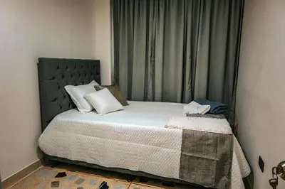 a bedroom with a bed with a green headboard at Apartamento Rosales in Medellín