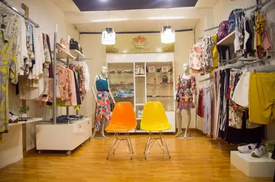 a clothing store with two yellow chairs in a room at Hotel Mall Santana Del Río in La Dorada