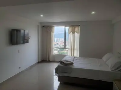 a bedroom with a bed and a large window at Mde Escape in Medellín