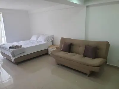 a bed and a couch in a room at Mde Escape in Medellín