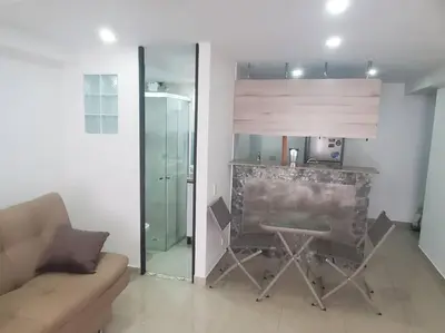 a living room with a table and a glass partition at Mde Escape in Medellín