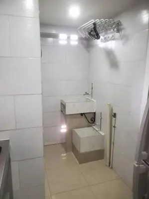 a white tiled bathroom with a sink and a mirror at Mde Escape in Medellín