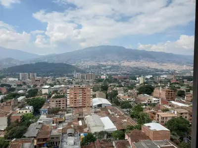 a city with buildings and mountains in the background at Mde Escape in Medellín