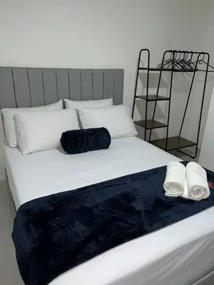 a bed with two white pillows and a blue blanket at Hotel San Juan 70 Express Medellin in Medellín