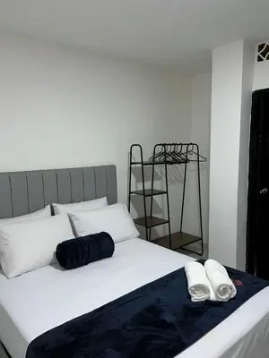 a bed with two pillows and a ladder in a room at Hotel San Juan 70 Express Medellin in Medellín