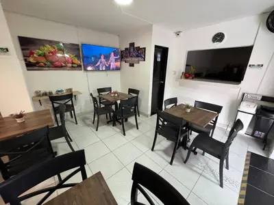 a restaurant with tables and chairs in a room at Hotel San Juan 70 Express Medellin in Medellín