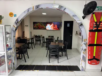 an archway in a restaurant with tables and chairs at Hotel San Juan 70 Express Medellin in Medellín