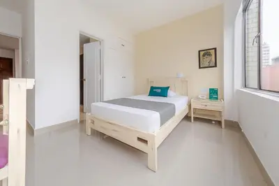 a white bedroom with a bed and a window at Hotel Ana Carolina in Manizales