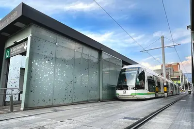 a train is parked next to a building at Indust in Medellín