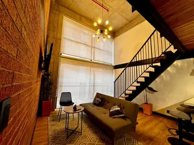 a living room with a couch and a staircase at Indust in Medellín