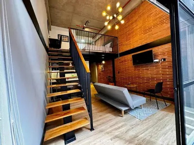 a staircase in a room with a couch and a chair at Indust in Medellín