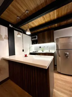 a kitchen with a white counter and a stainless steel refrigerator at Indust in Medellín