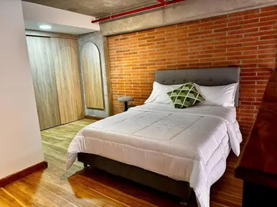a bed in a room with a brick wall at Indust in Medellín