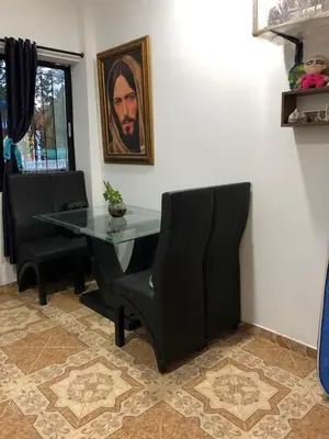 a dining room with a glass table and a black chair at Casa santorini in Puerto Triunfo