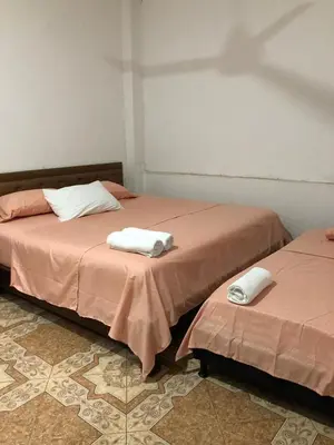 two beds sitting next to each other in a room at Casa santorini in Puerto Triunfo