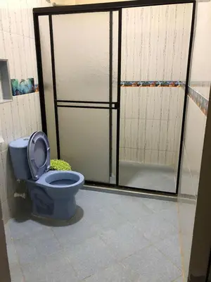 a bathroom with a blue toilet and a door at Casa santorini in Puerto Triunfo
