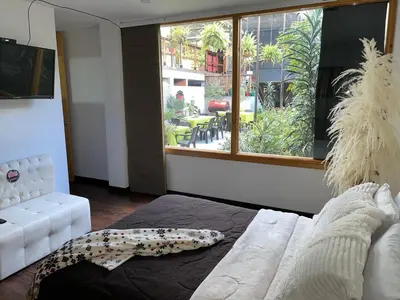 a living room with a white couch and a large window at Athos Hotel Boutique in Bolivia