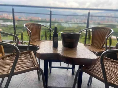 a wooden table with a bottle of wine on it at Penthouse Estadio Medellín in Medellín