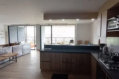 a kitchen with a counter top and a large window at Penthouse Estadio Medellín in Medellín