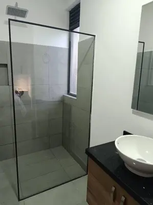 a bathroom with a glass shower and a sink at Penthouse Estadio Medellín in Medellín