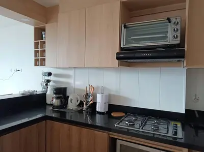 a kitchen with a stove and a microwave at Penthouse Estadio Medellín in Medellín