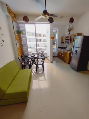 a living room with a green couch and a kitchen at Mi Paraíso in Sopetran