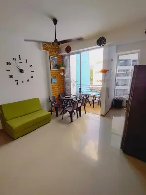 a living room with a green couch and a clock on the wall at Mi Paraíso in Sopetran