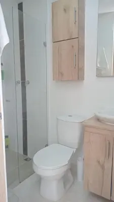 a white bathroom with a toilet and a sink at Hermoso aparta estudio en Medellin in Medellín