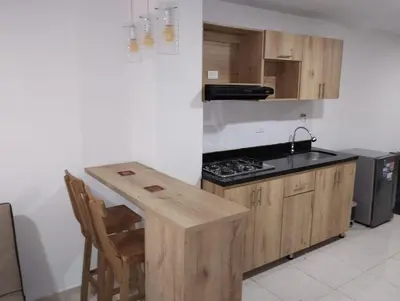 a kitchen with a stove and a wooden table at Hermoso aparta estudio en Medellin in Medellín